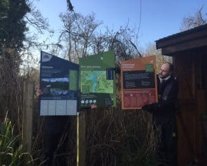 Alex holding up the first draft of the signage on the Nature Trail